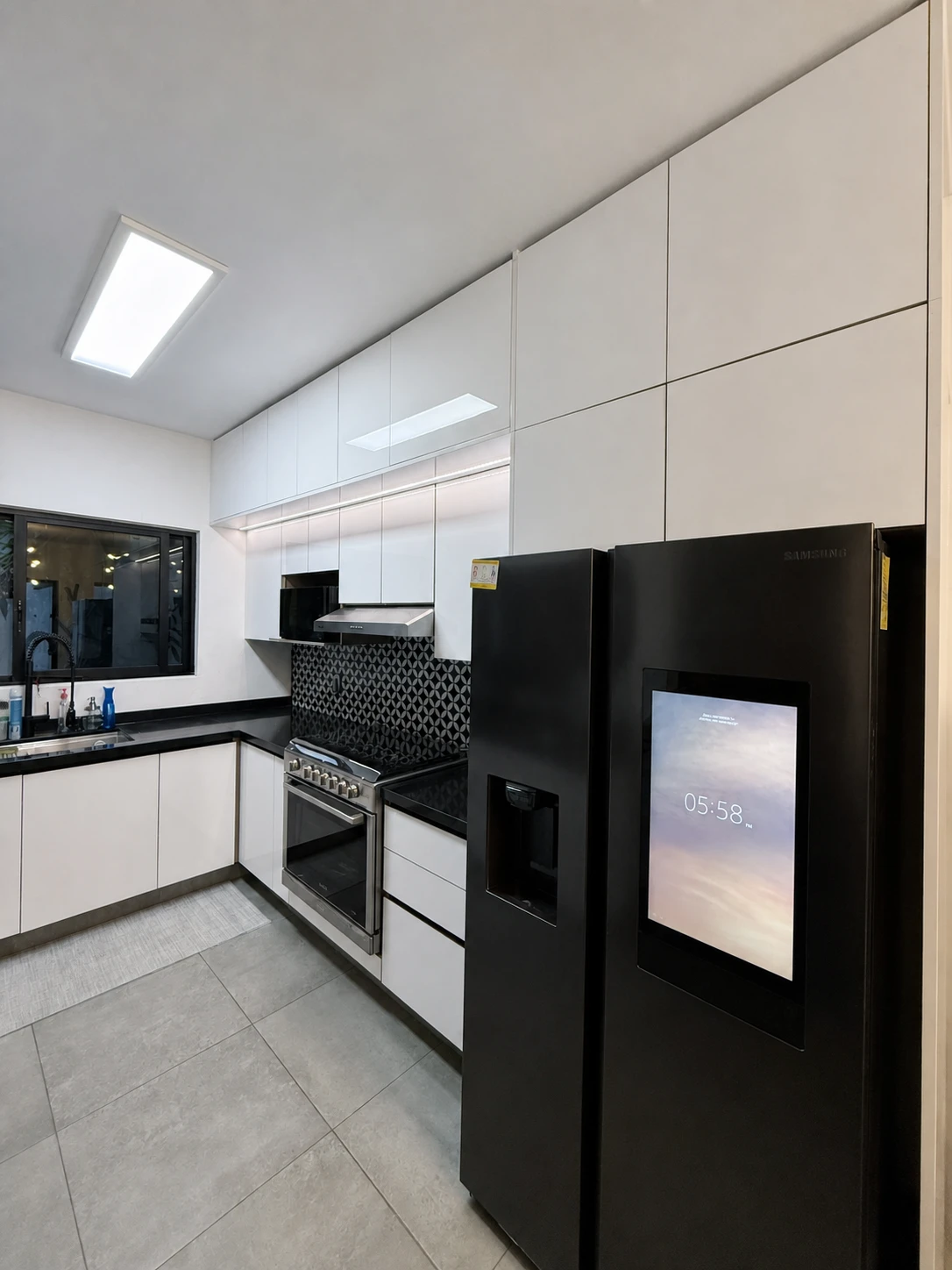 Cocina Casa Santoni con gabinetes blancos, cubierta negra y estufa de acero inoxidable
